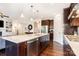 Beautiful island with a sink, seating, and stainless steel dishwasher in a kitchen with dark wood cabinets at 11225 Black Brant Ln, Charlotte, NC 28278