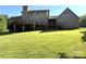 Expansive backyard with a large brick home featuring a chimney and a wooden deck at 1335 33Rd Avenue Ne Dr, Hickory, NC 28601