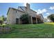 The rear exterior showcasing a brick facade, wooden deck, and lush green lawn under a sunny sky at 1335 33Rd Avenue Ne Dr, Hickory, NC 28601