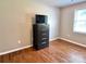 Neutral bedroom offering hardwood floors and a dark wood chest with television at 147 Dutchman Rd, Harmony, NC 28634