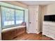 Cozy window seat nestled next to a door and dresser in this bedroom with hardwood floors at 147 Dutchman Rd, Harmony, NC 28634