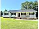 Charming one-story home featuring a welcoming front porch, green lawn and a durable metal roof at 147 Dutchman Rd, Harmony, NC 28634