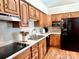 Efficient kitchen with wood cabinets, black appliances, and durable countertops at 147 Dutchman Rd, Harmony, NC 28634