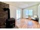 Cozy living room features a brick fireplace, wood floors, and natural light from the sliding doors at 147 Dutchman Rd, Harmony, NC 28634