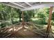 A covered porch offering views of a lush green backyard and wooded area at 1541 Kings Rd, Shelby, NC 28150