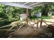 A porch overlooking a yard and two outbuildings that are surrounded by lush trees and greenery at 1541 Kings Rd, Shelby, NC 28150