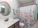 Charming bathroom with a round mirror, decorative shower curtain, and coordinating floral accents at 15739 Circlegreen Dr, Charlotte, NC 28273