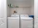 Efficient laundry room with washer, dryer, and overhead shelving for convenient storage at 15739 Circlegreen Dr, Charlotte, NC 28273