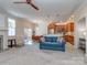 Open-concept living area with a fireplace and adjoining kitchen featuring warm-toned cabinetry at 15739 Circlegreen Dr, Charlotte, NC 28273