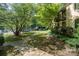 Inviting walkway to the building entrance, beautifully landscaped with mature trees and lush greenery at 207 N Dotger Ave # C14, Charlotte, NC 28207
