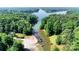 Aerial view of a property with lake access featuring multiple boat docks and a lush tree line at 260 River Country Rd, Salisbury, NC 28146