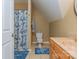 Cozy bathroom with blue floral shower curtain, matching rugs, and a light wood vanity at 260 River Country Rd, Salisbury, NC 28146