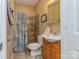 Well-lit bathroom featuring a tiled shower with floral curtains, a wooden vanity, and modern fixtures at 260 River Country Rd, Salisbury, NC 28146