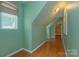 Hallway with green walls, hardwood floors, natural light, and doorway to a bedroom at 260 River Country Rd, Salisbury, NC 28146