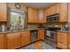 A cozy kitchen featuring stainless steel appliances, wooden cabinetry, granite countertops, and a garden window at 260 River Country Rd, Salisbury, NC 28146
