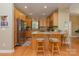 Well-lit kitchen featuring wood cabinets, stainless steel appliances, and a cozy breakfast bar with wooden stools at 260 River Country Rd, Salisbury, NC 28146