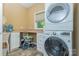 Practical laundry room with a stacked washer and dryer, ample counter space, and storage cabinets at 260 River Country Rd, Salisbury, NC 28146