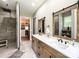 This bathroom has a double vanity, a tiled walk-in shower, and leads into a well-organized walk-in closet at 4023 Yesteryears Ln, Marshville, NC 28103