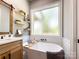 This bathroom features a soaker tub, a large window, and floating shelves next to the vanity at 4023 Yesteryears Ln, Marshville, NC 28103