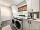 Modern laundry room with white cabinetry, sleek countertops, and efficient washer/dryer units at 4023 Yesteryears Ln, Marshville, NC 28103