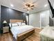 This main bedroom features a statement wall, wood floors, a ceiling fan, and access to a closet at 4023 Yesteryears Ln, Marshville, NC 28103