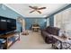 Spacious living room featuring blue walls, shutters, and a comfy leather couch at 409 E 18Th St, Kannapolis, NC 28083