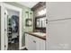Well-lit bathroom featuring a stone backsplash, modern vanity with storage, and a convenient closet area at 4567 Hickory Grove Rd, Sharon, SC 29742