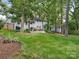 A lush backyard with green grass and mature trees surrounding the property at 4618 Emory Ln, Charlotte, NC 28211