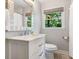 Bathroom with a white vanity, modern fixtures, framed mirror, and a window with a view to the outdoors at 4618 Emory Ln, Charlotte, NC 28211