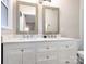 Bathroom with a double vanity, white marble countertop, and dual mirrors and views of the outdoors at 4618 Emory Ln, Charlotte, NC 28211