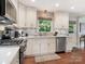 Bright kitchen featuring white cabinets, stainless steel appliances, and hardwood floors at 4618 Emory Ln, Charlotte, NC 28211