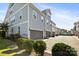 Exterior view of townhomes with neutral siding, dark grey garages, and well-maintained landscaping along the driveway at 5008 Calvine Mill Way, Charlotte, NC 28205