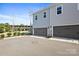 View of grey townhomes with large dark grey garages and well-kept landscaping, set against a clear blue sky at 5008 Calvine Mill Way, Charlotte, NC 28205