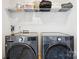 Laundry room with stainless steel washer and dryer and wire shelving at 5008 Calvine Mill Way, Charlotte, NC 28205