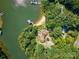Aerial shot showcases a private lakefront home with a sandy beach, dock, and lush trees at 5390 Hudson Rd, Clover, SC 29710