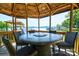 Enclosed gazebo featuring a stylish table and chairs with a view of the lake at 5390 Hudson Rd, Clover, SC 29710