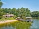 Lakefront home with a private sandy beach, docks, lush landscaping, and tranquil lake views at 5390 Hudson Rd, Clover, SC 29710