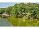 Lush green lakefront property with a private beach and dock surrounded by trees at 5390 Hudson Rd, Clover, SC 29710