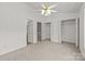 Bright bedroom with neutral carpet, ceiling fan, and closet access at 5724 Cougar Ln, Charlotte, NC 28269