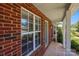 Brick facade featuring a large window, porch, and garden bed at 5724 Cougar Ln, Charlotte, NC 28269