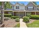 Well-maintained townhome featuring a brick facade, lush greenery, and cozy front porch at 5724 Cougar Ln, Charlotte, NC 28269
