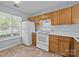 Functional kitchen featuring white appliances and wooden cabinets at 5724 Cougar Ln, Charlotte, NC 28269