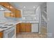 Practical kitchen with white appliances, wooden cabinetry, and view to the dining area at 5724 Cougar Ln, Charlotte, NC 28269