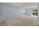 Comfortable living area with carpet, sliding glass door, and a chandelier at 5724 Cougar Ln, Charlotte, NC 28269