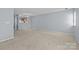 Large living area featuring neutral carpet, and open layout with a glimpse of the kitchen at 5724 Cougar Ln, Charlotte, NC 28269