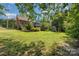 Beautiful backyard featuring green grass, a blue sunshade, some trees and a shed at 610 Mountain Pl, Albemarle, NC 28001