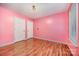Bright bedroom featuring pink walls, hardwood floors, and natural light from the window at 610 Mountain Pl, Albemarle, NC 28001
