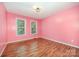 Empty bedroom with wood floor, light fixture and windows overlooking the yard at 610 Mountain Pl, Albemarle, NC 28001