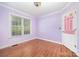 Bedroom with lilac walls, hardwood floors, and a large window at 610 Mountain Pl, Albemarle, NC 28001