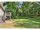 View of the expansive backyard with mature trees and a deck at 6515 Santa Cruz Trl, Charlotte, NC 28227
